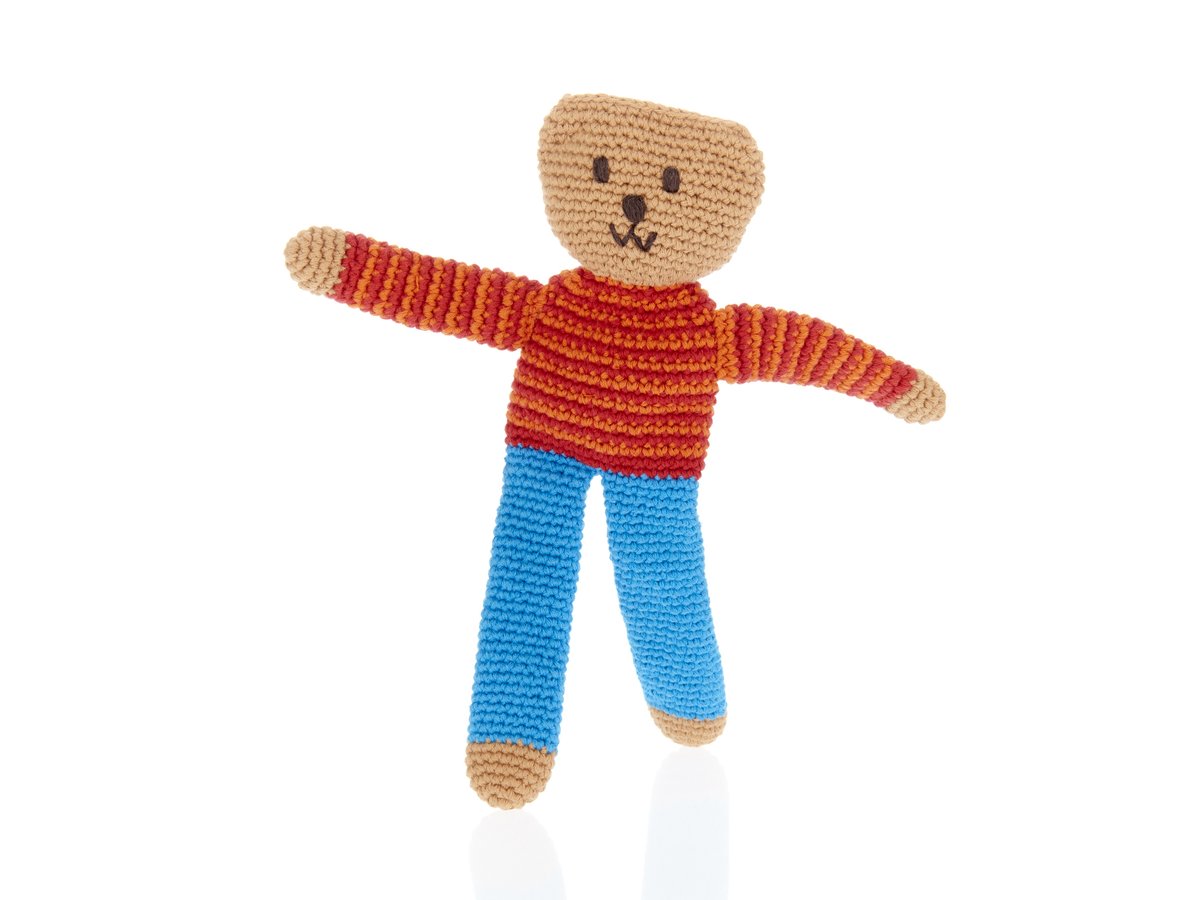 Crochet first teddy bear soft toy with long legs in blue trousers and red and orange stripe jumper.