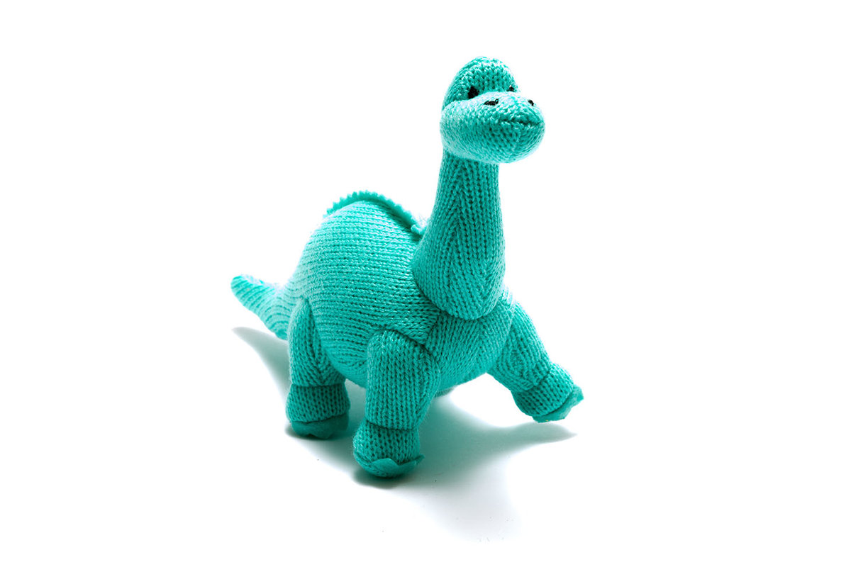Small knitted diplodocus dinosaur baby toy with long neck and smiley face knitted in vivid ice blue yarn