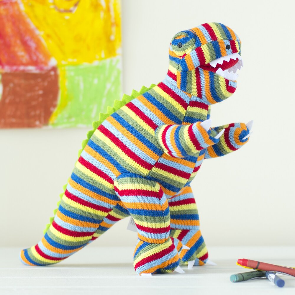 Greetings card featuring stripe knitted T Rex soft toy with crayons on floor and painting behind